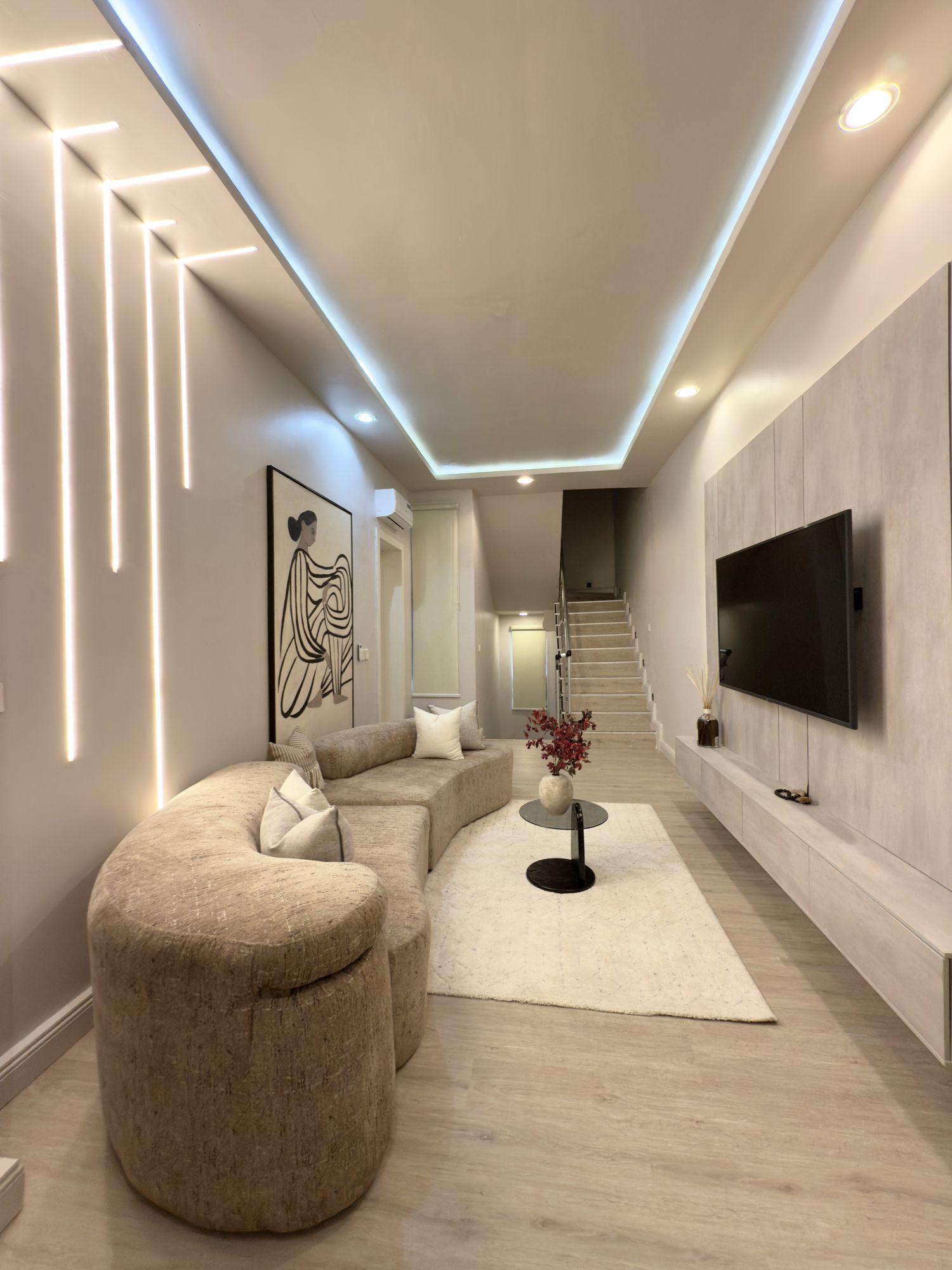 Lounge with vertical light lines on the wall and the staircase beyond