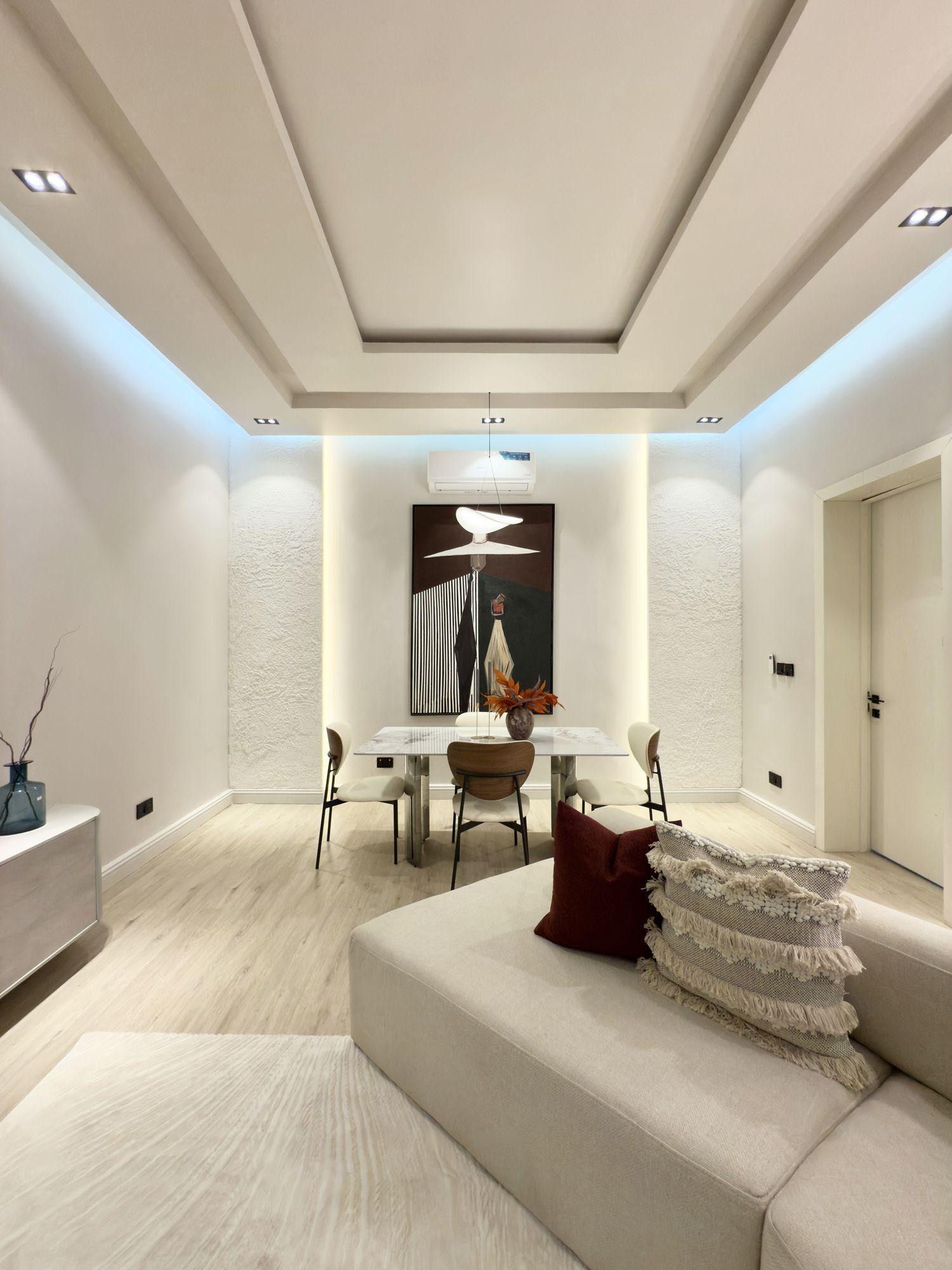 Dining space with backlit textured piers framing a large abstract painting