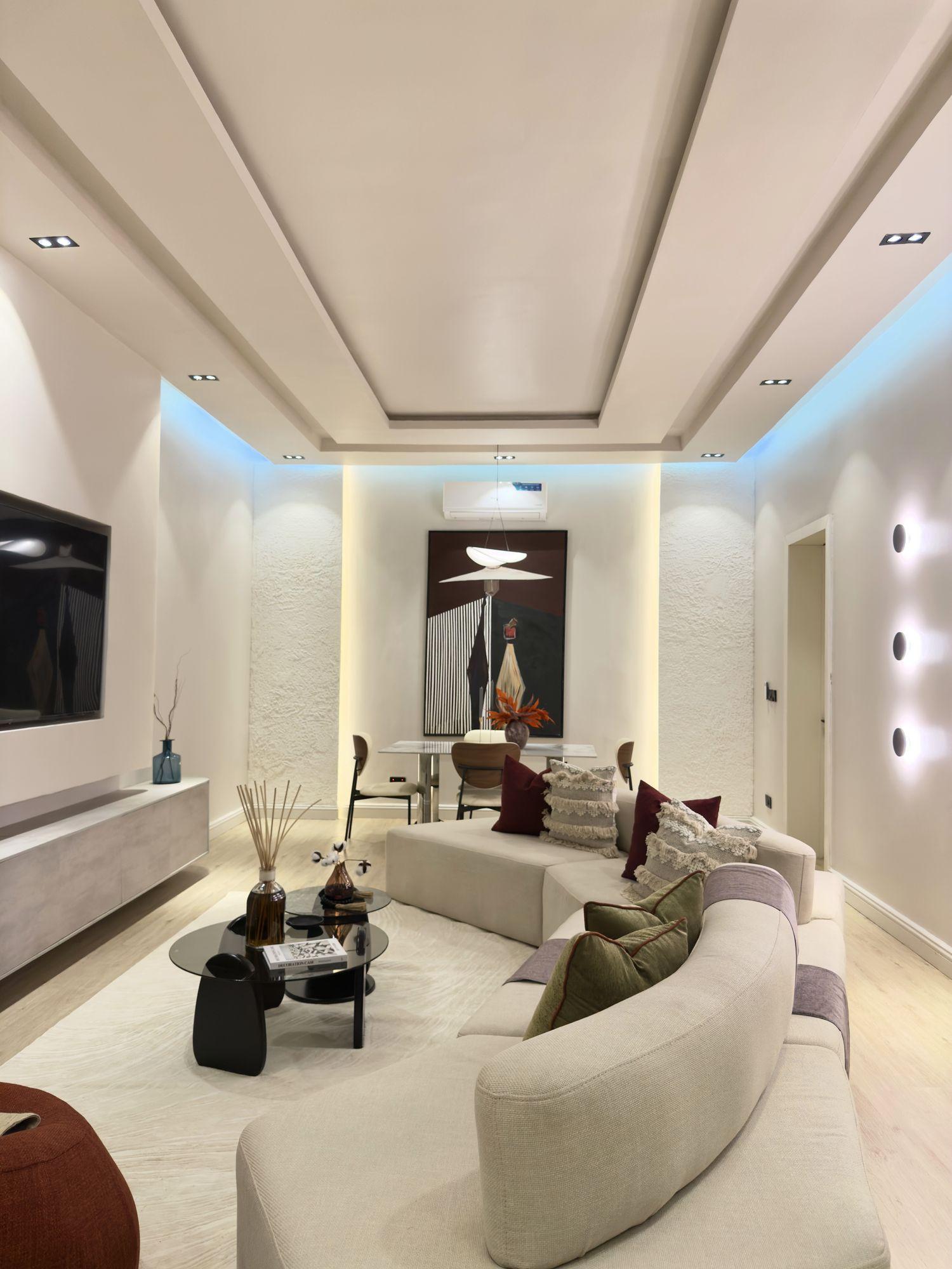 Living room facing a recessed television wall under stepped ceiling coffers