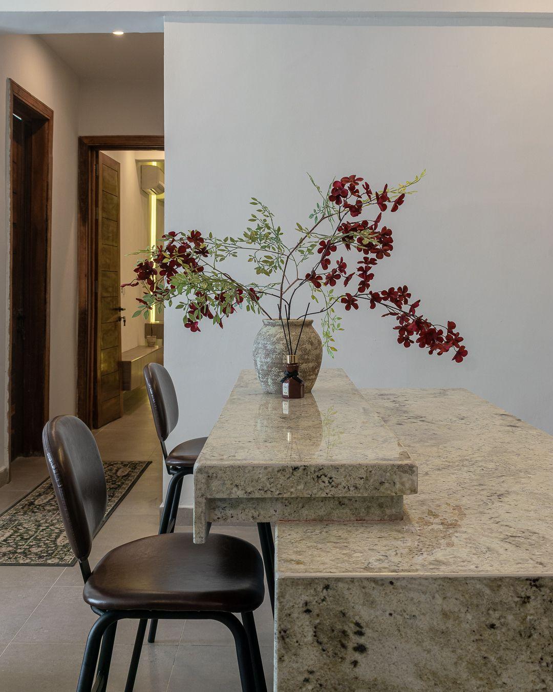 Granite breakfast counter with leather bar stools and dried florals